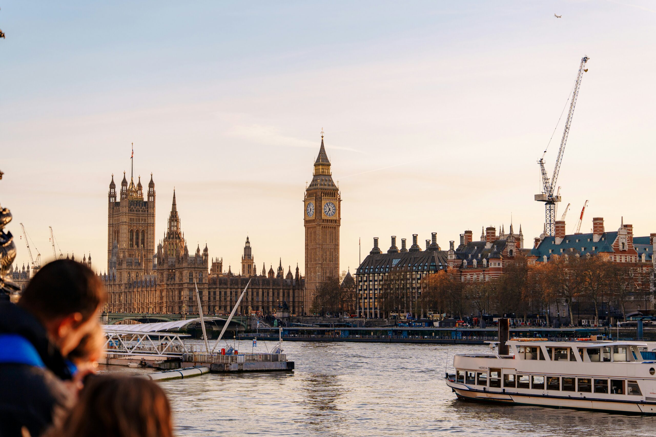 Thames River Sightseeing boat Mercia cruising past Big Ben and the Houses of Parliament in London.