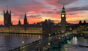 View of the Palace of Westminster and Big Ben from the River Thames during a sunset