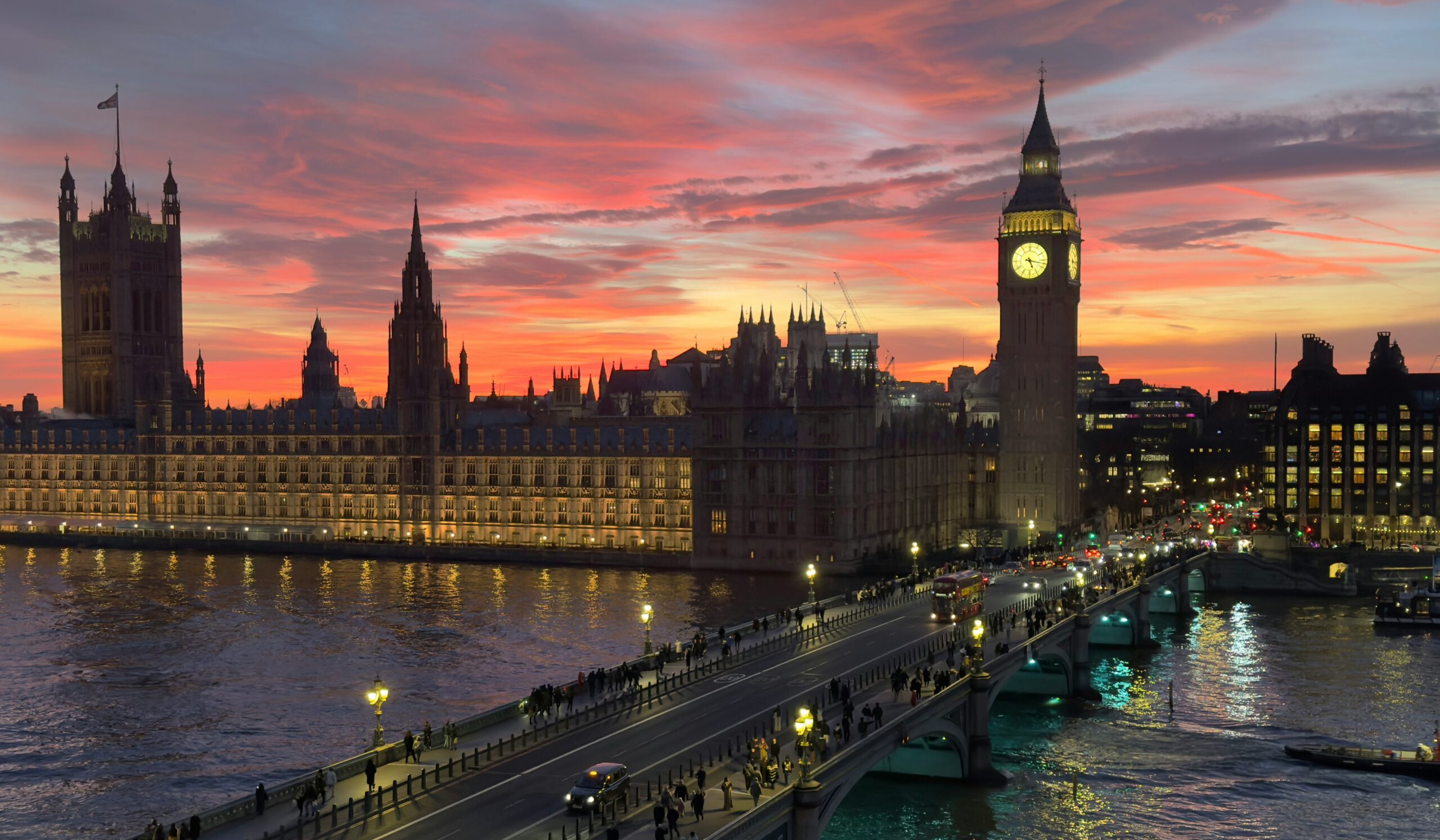 View of the Palace of Westminster and Big Ben from the River Thames during a sunset