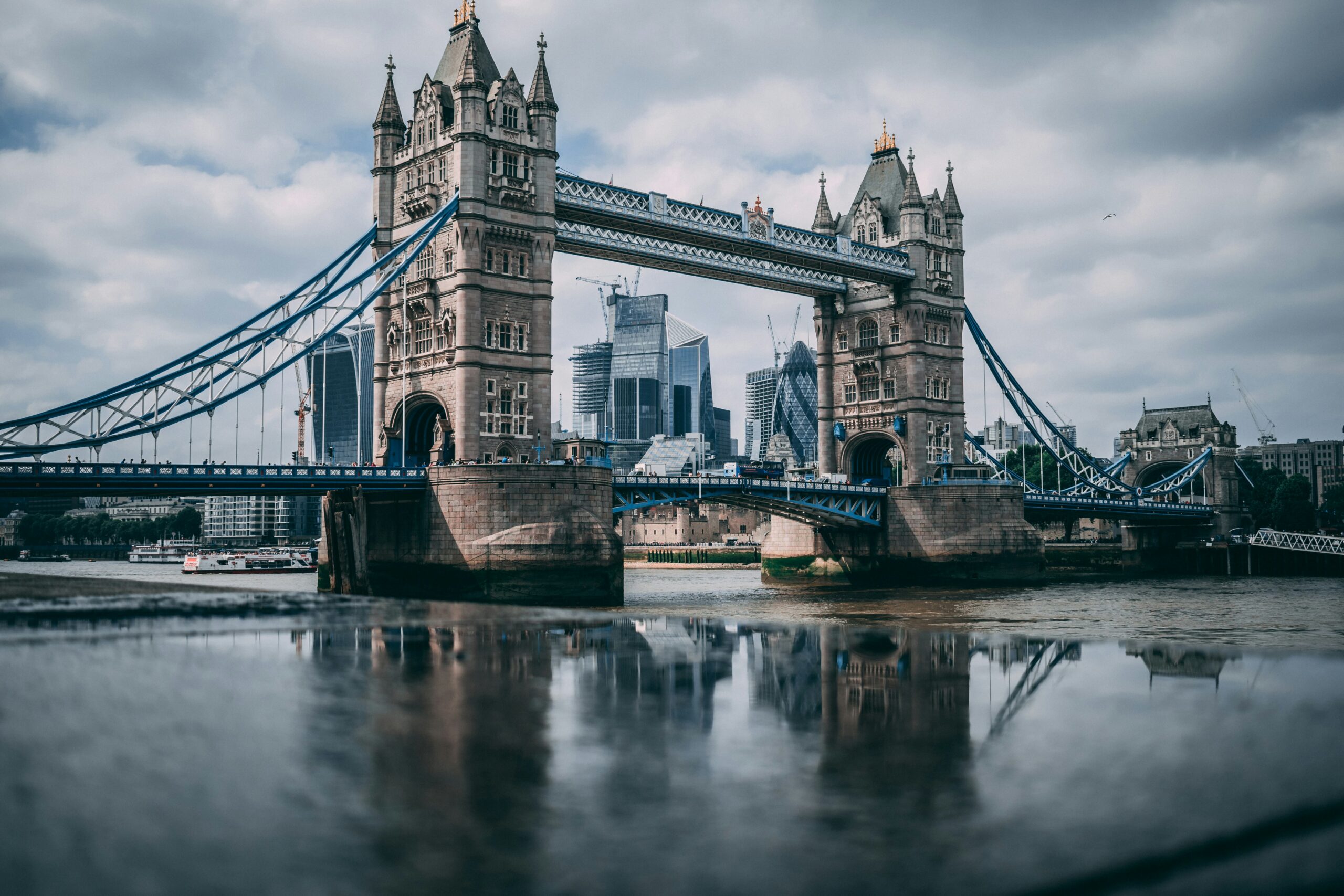 Tower Bridge London landmark with River Thames and city skyline under overcast sky